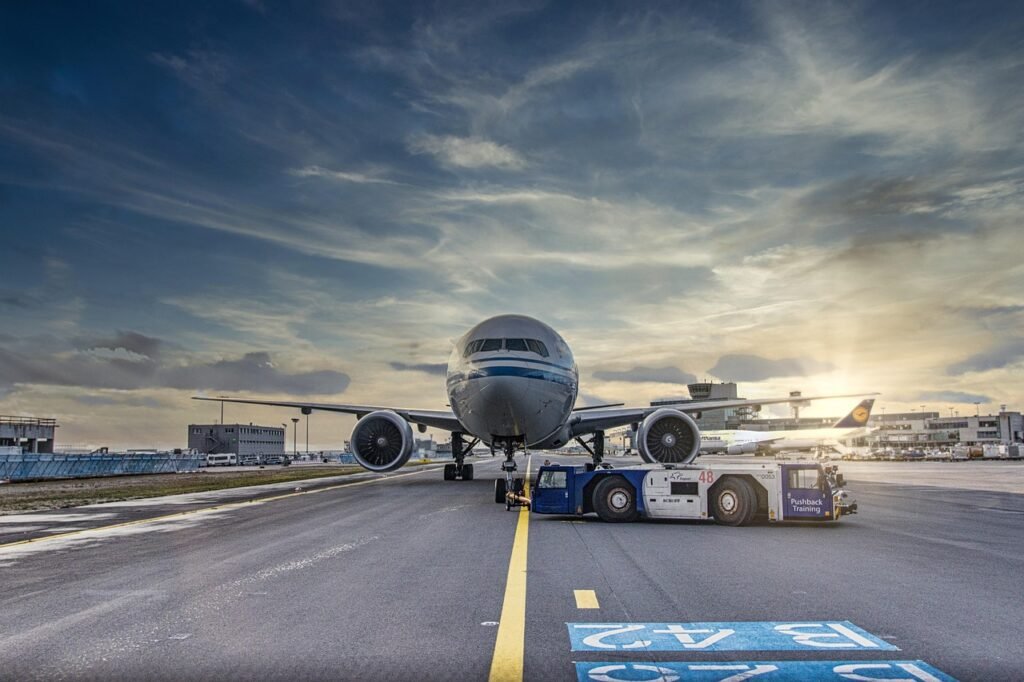 airplane, runway, airport, tarmac, aircraft, vehicle, truck, airliner, clouds, asphalt, jet, flight, nature, transportation system, air travel, outdoor, airline, plane, transportation, travel, airfield